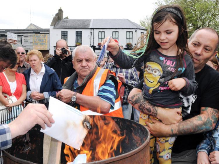 Aoife Dunne, Rosbrien, pictured with her father, John, burning their Irish Water Bill at City Hall in Limerick. Picture: Gareth Williams