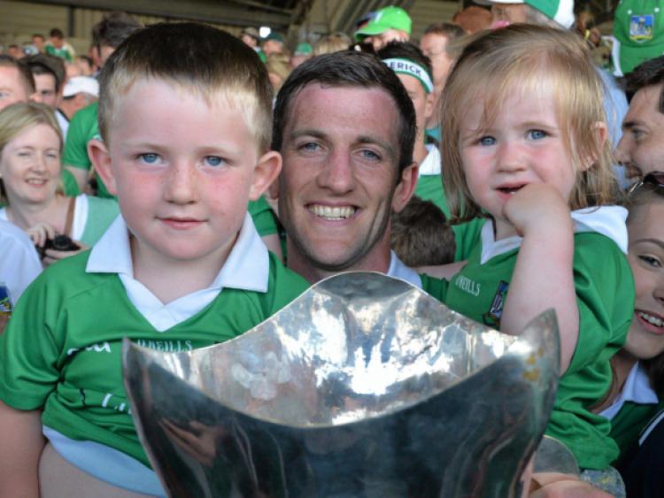 Limerick captain Donal O'Grady holds the cup, along with his children, Danny, aged 3 and a half, and Anna, aged 2, after the Munster final victory over Cork at the Gaelic Grounds