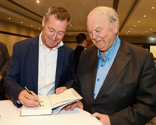 Former finance minister Michael Noonan gets his copy of Charlie vs Garret signed by Corbally-born academic and writer Eoin O’Malley  | PICTURE: Adrian Butler