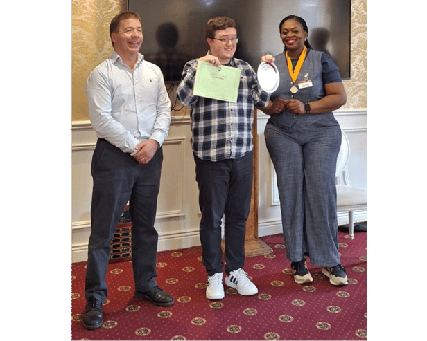 Adam Cronin, receiving his plaque, pictured with Paul McCarthy, and Angela Afieghe at the Toastmasters Evaluation Contest