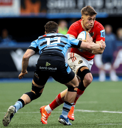 Jack Crowley of Munster is tackled by Harri Millard of Cardiff during the URC fixture at the Arms Park on Friday night