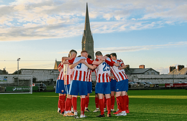 Treaty United players in a huddle with the spire of St John's Cathedral in the background | PICTURE: Kieran Ryan-Benson