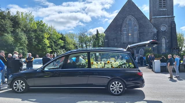 The hearse, with flowers spelling Shay's name, waiting outside St Senan's Church in Clonlara | Picture: Ellen Gough