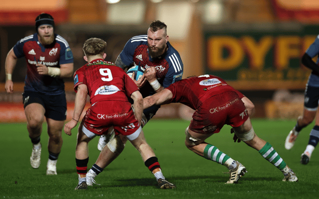 RG Snyman, of Munster, is tackled by Alex Craig of Scarlets during the URC fixture at Parc y Scarlets on Friday night | PICTURE: Sportsfile