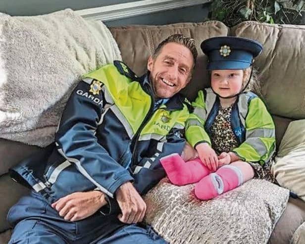 Mia Farrell, age five, with her best friend Garda Ollie O'Sullivan who visited her home during Easter |  PICTURE: An Garda Siochana/Twitter