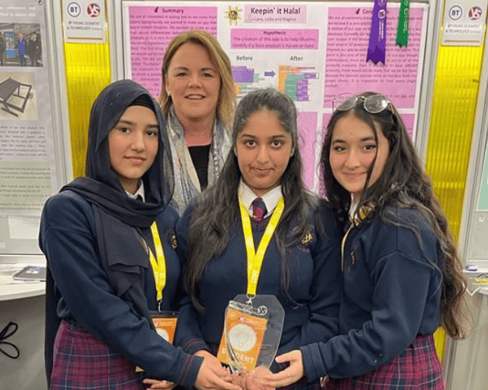 Dr Pamela Byrne from the Food Safety Authority of Ireland (behind) presenting the Food Safety Authority of Ireland Special Award to 2nd Year students Wagma, Laiba and Lana from Coláiste Nano Nagle