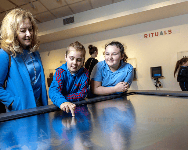 Teacher Eileen McGiff with AJ Buckley and Maria McMahon, 4th class pupils from St Mary's NS, Limerick  city, using the interactive timeline to explore the story of clay and ceramics at 'Made of Earth’