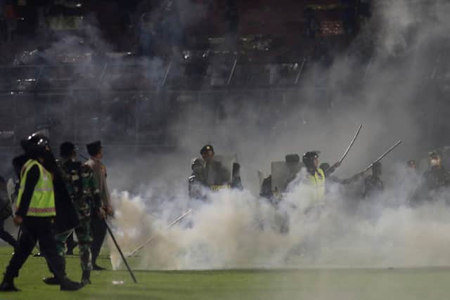Fans ran onto the pitch after the final whistle and police then fired tear gas, leading to the stampede.
