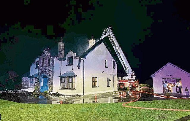 Fire crews battling both the fire and strong winds and rain at the O'Shaughnessy family home in Ballyhahill on Sunday