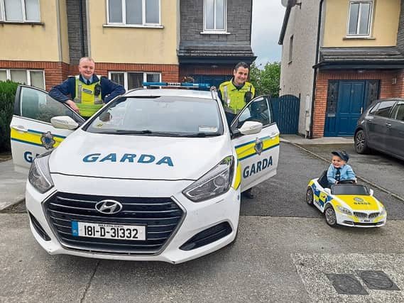 Noah Quish, Monaleen, shows Garda James Keehan and Garda David Stapleton his patrol car and then tries their one out for size