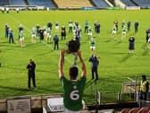 A long way from the snug: Limerick captain Declan Hannon lifts the cup in front of his team-mates in an empty stadium after the Munster GAA Hurling Senior Championship Final