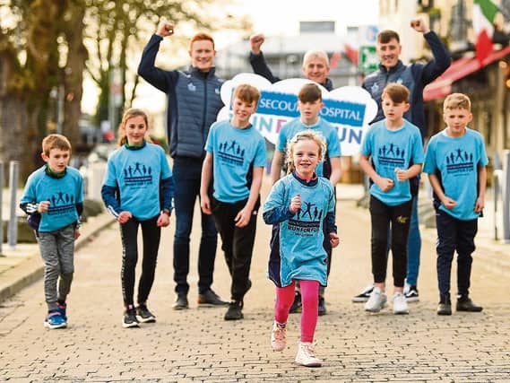Limerick hurling boss John Kiely with players Will O'Donoguhe and Diarmaid Byrnes launch the fun run with a little help from young athletes