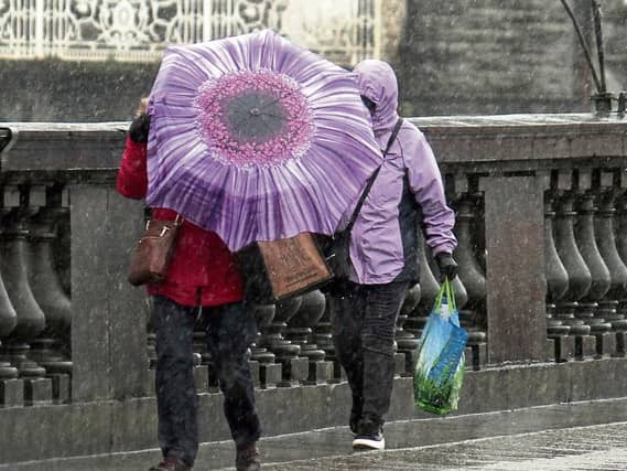 Outside the world of politics - Ireland’s second favourite subject, the weather, has been down right miserable. Pictured are two brave souls trying to cross Sarsfield Bridge Picture: Michael Cowhey
