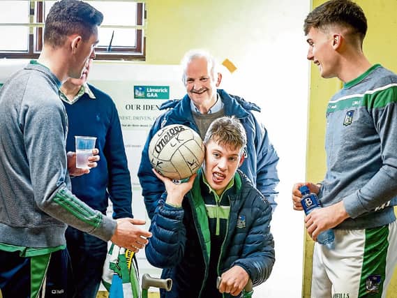 Darragh pictured in the team's dressing room with football board chairman Gerry Phillips, Monagea, Adare footballer Paul Maher and Colm McSweeney, Gerald Griffins
