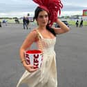 Limerick influencer Chloe Koyce  pictured showcasing a bespoke KFC-inspired fascinator and matching bucket bag, designed by Irish designer Maya Grisham at the Galway Races
PICTURE: Galway Races