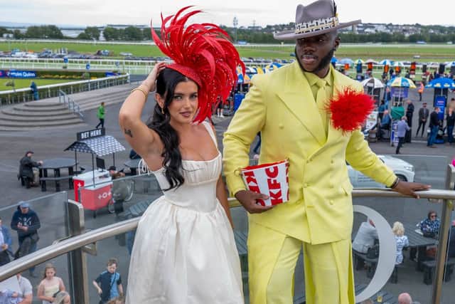 Fashionista Chloe Koyce and fashion stylist Emmanuel Agbons debut a bespoke KFC-inspired fascinator and matching bucket bag, designed by Irish designer Maya Grisham, at Ballybrit Racecourse on Tuesday 
PICTURE: Galway Races