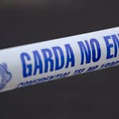 Garda no entry tape stretched across a road