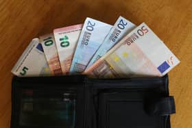 Euro notes sit inside a wallet