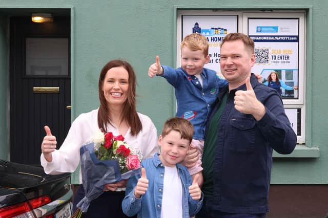 Jacqueline O'Gorman from Cratloe, Co Clare but living in Oranmore, Co, Galway outside the home she won in Oranmore Maree GAA One Club Win A Home draw with her husband Richard Kiely and children Sam and George