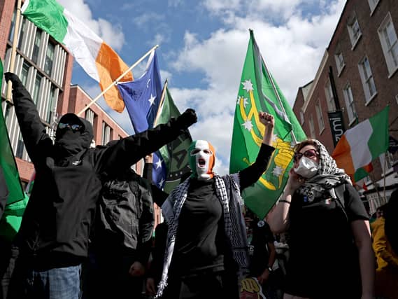 Protesters with the faces covered by balaclavas and masks take part in an anti-Trump protest march