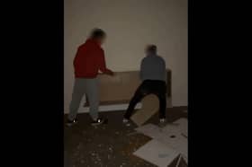 Videos of the incident show young people throwing a bookshelf through a window