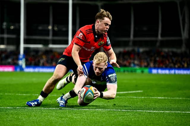 Jamie Osborne of Leinster dives over to score his side's fourth try despite the tackle of Charlie O'Shea