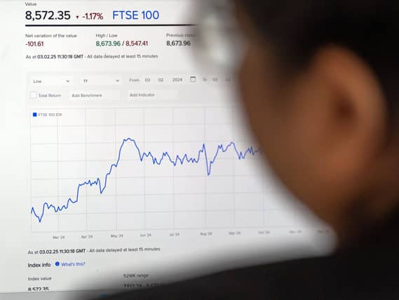 A man looks at the FTSE 100 on a screen