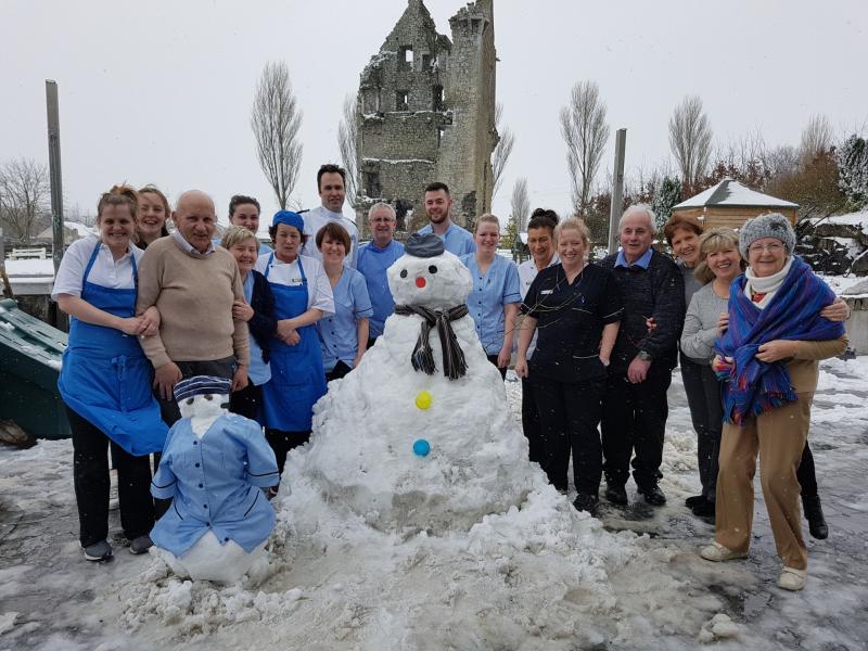 Staff and residents of St Anthony's Nursing Home build a snowman and snow nurse