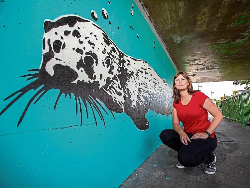 Mary Conroy beside the mural she created under the Shannon Bridge Pictures: Alan Place