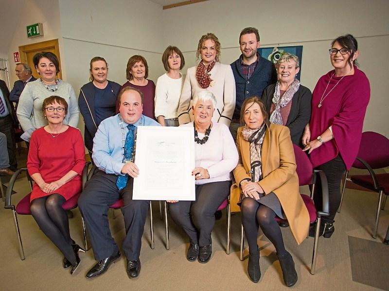 Margaret O’Shaughnessy, surrounded by members of staff from Foynes Flying Boat and Maritime Museum receiving her scroll of honour from Cllr Adam Teskey, cathaoirleach, Adare Rathkeale