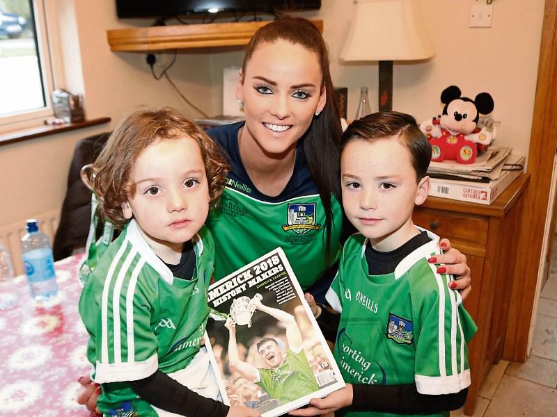Limerick ladies footballer Amy Ryan, Doon, with her sons Tommy and Billy enjoying the Leader's hurling book Picture: Michael Cowhey