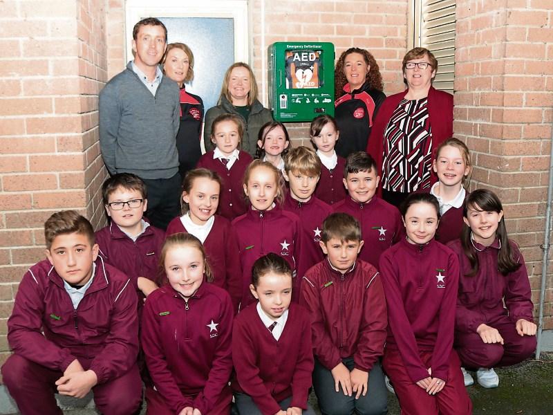 Members of An Bru AC, teachers and pupils of Scoil Dean Cussen in Bruff with the newly erected defibrillator that was bought by An Bru for the whole community Picture: Michael Cowhey 