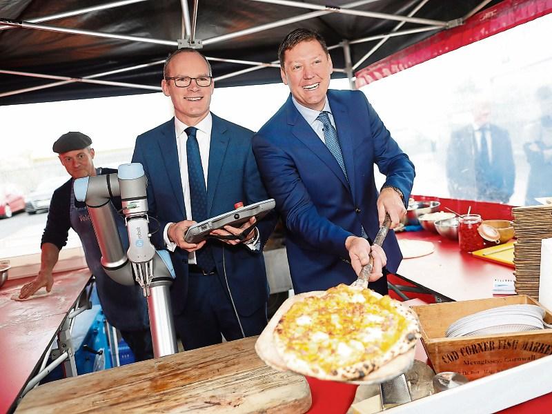 Tánaiste Simon Coveney and Reliance managing director Peter Creighton after using a ‘cobot’ to cut pizza at the company’s new facility in Limerick Picture: Julien Behal