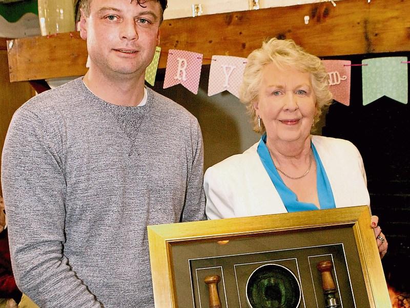 Damien O'Dwyer presents a framed stamps and ink pad to Mary McKenna