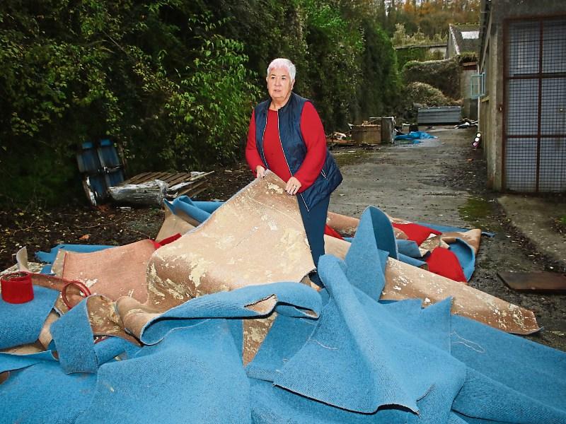 Foynes: Margaret O’Shaughnessy with the destroyed carpet at the Foynes Museum Picture: Michael Cowhey