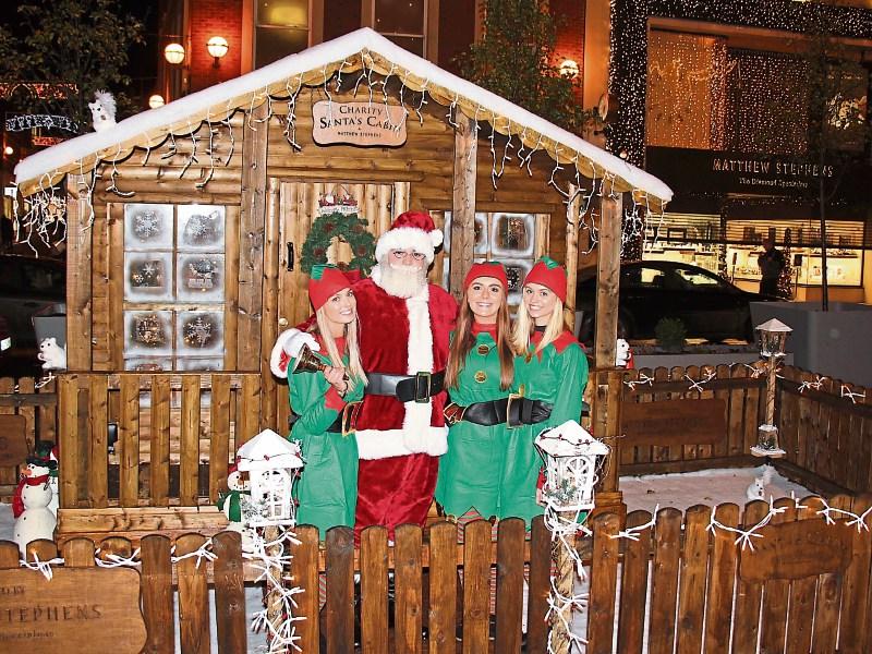 Elves Saoirse Hammond, Emma O’Reilly and Isobel Cox with Santa outside the Cabin for Barnados