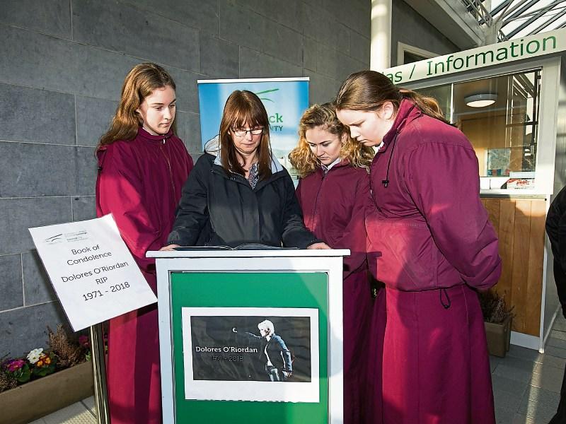 Laurel Hill Colaiste Principal Aedín Ní Bhriain with students Christine O’Brien, Ciara Deegan and Sophie O’Callaghan signing the book of condolence