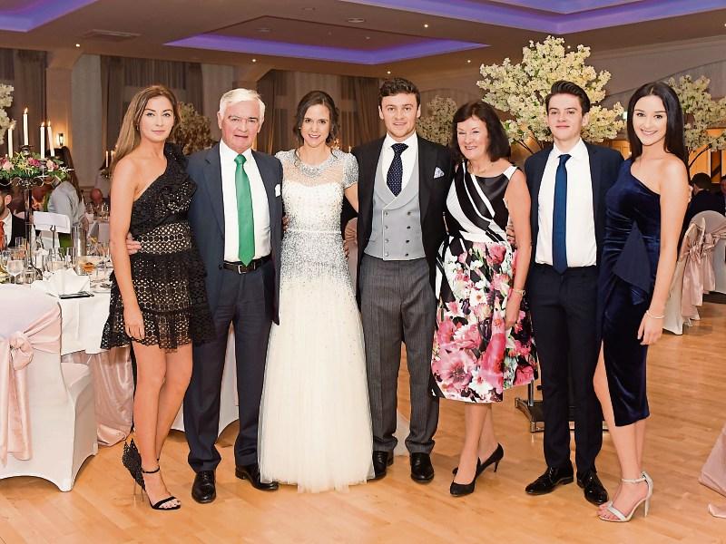 The Long family in the Longcourt House Hotel ballroom. Centre are newly-weds James Jnr and Rose, with, from left, Mary Louise, Jim, Mary, Jonathon and Frances Picture: Black Diamond Photography