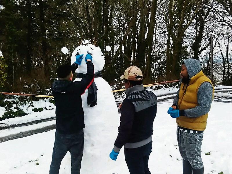 William Walker, Malawi, pictured in centre, building a snowman with friends at Mount Trenchard