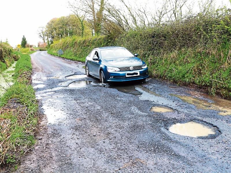 Easy does it: A motorist cautiously approaches the giant pothole near Ballynamona Cross between Hospital and Herbertstown on Monday    Picture: Michael Cowhey
