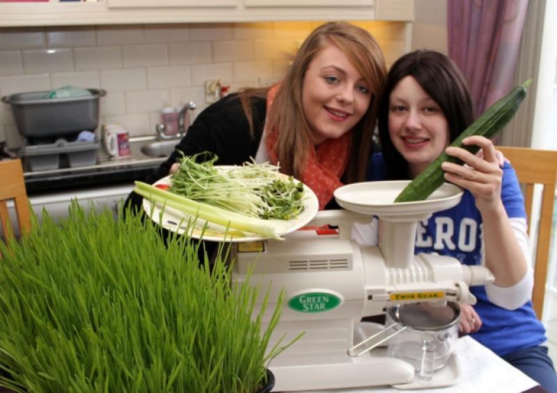 Stephanie O'Halloran, 23, from Garryowen, with her sister Carrie, showing some of the green organic produce are pictured inset, and below, with her many supporters following a recent benefit night in the Greenhills hotel. Pictures: Michael Cowhey