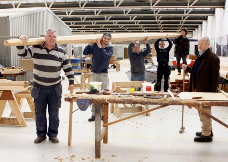 All hands on deck: Robert Small, Ballinacurra; Lee Triantafillidis, Raheen; James Madigan, Lissycasey; Gary Wilmott, Castletroy; Matt Dirr, North Circular Road and Fr Anthony Keane, Glenstal, at the Ilen School and Network for Timber Boat Building and below, Kate Jarvey, Ruth Lilly Philanthropic Foundation, and Minister for the Marine Simon Coveney jointly nailing home the whiskey plank into the Ilen's hull