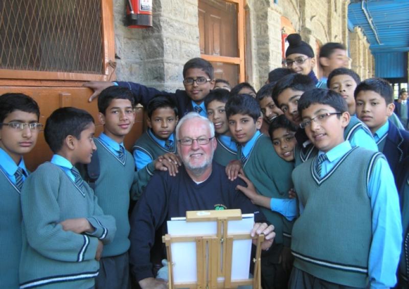 Jim OFarrell painting in Nainital in the north of India, surrounded by a group of interested students