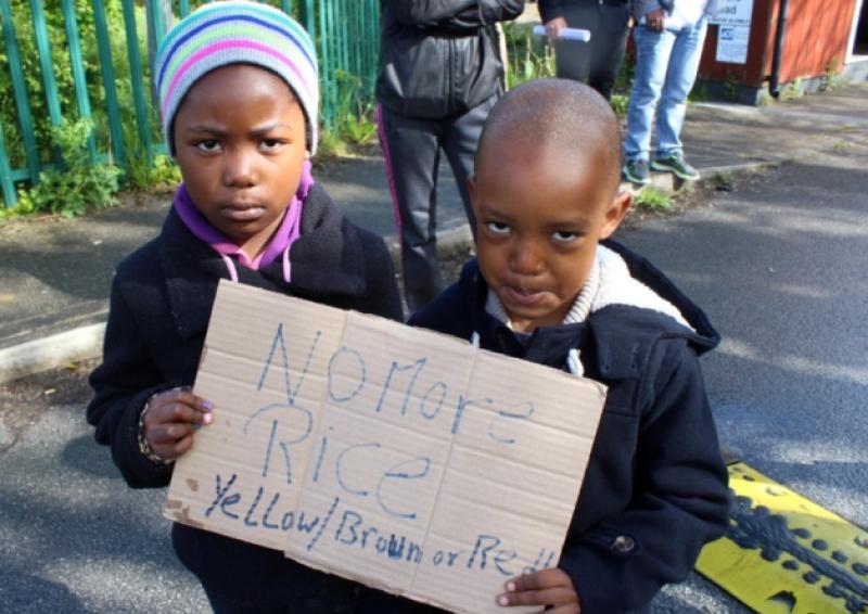 Seven-year-old Alexandra and five year old Aston Vuma from Nigeria have a clear message for management at Knockalisheen, 'No More Rice', and below, the menu for this Wednesday, issued by the department of justice