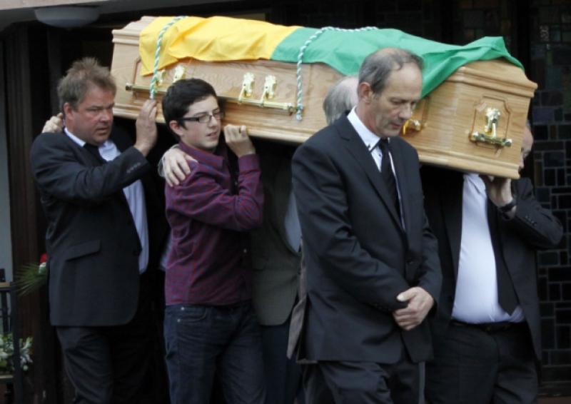 Fr Liam Ryan's coffin, draped in the Cappamore GAA colours, being carried to his final resting place in the church grounds and below, the late Fr Liam Ryan, Cappamore