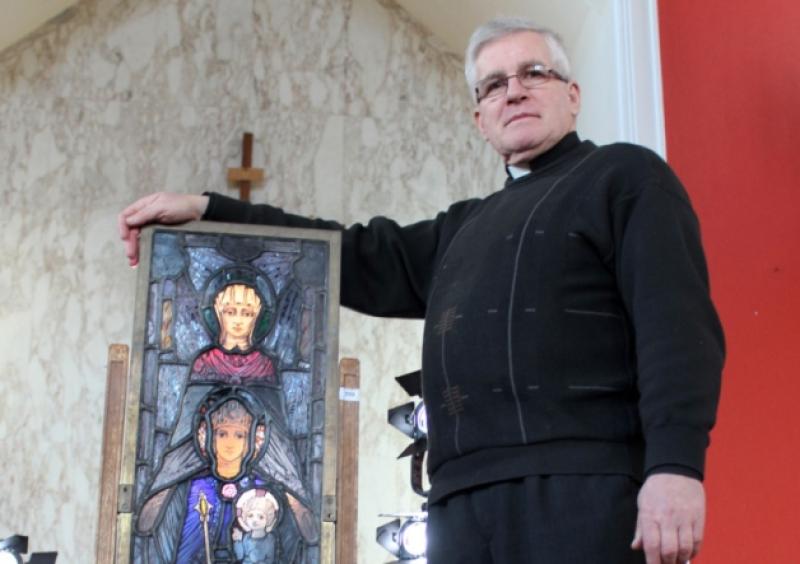 Fr John Donworth, the parish priest of Kildimo and Pallaskenry, with the stained glass reclaimed by the community. Picture: Michael Cowhey