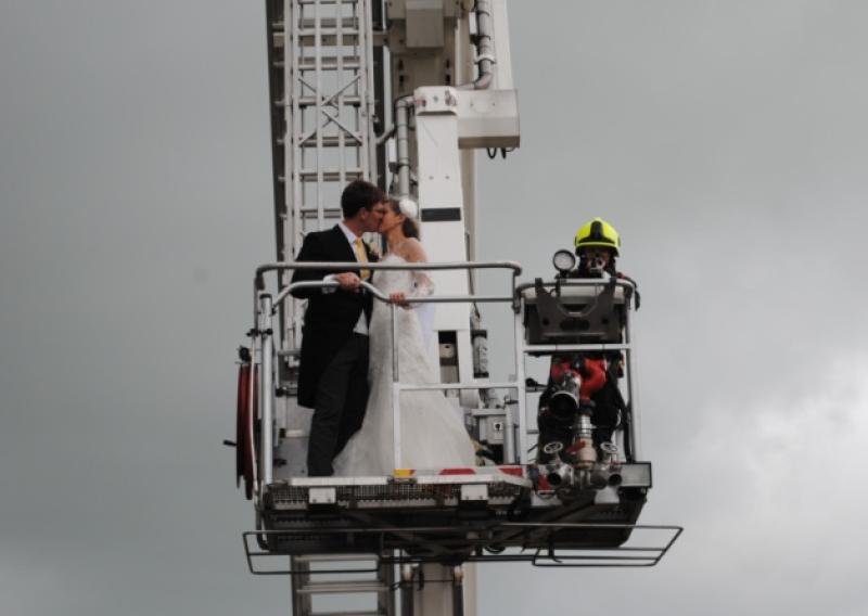 Well known horse trainer Harry Fry and Ciara O'Connor from Askeaton who got married in Adare on Saturday at the same time as a fire broke out on the historic thatched cottages across the road. Local photographer Liam Woulfe captured this picture of them on the fire brigade hoist after the blaze had been brought under control