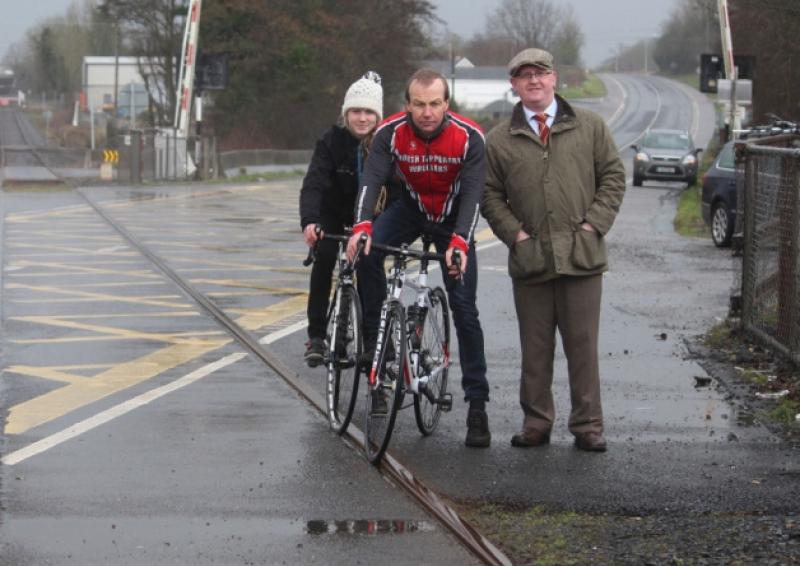 Turlough Herbert with Eva and her dad Peter Moynan on their bikes at the railway crossing at Lisnagry and below, the warning signs. Picture: Michael Cowhey