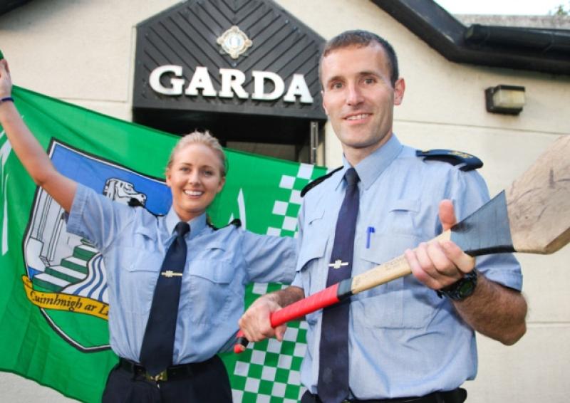 Garda Michelle Carroll, Limerick, holds the Limerick colours in advance of the Munster Hurling final, with her collegue Gerry O'Connor, former Cork Hurler, who is also based at Bruff garda station [Picture: Dermot Lynch]