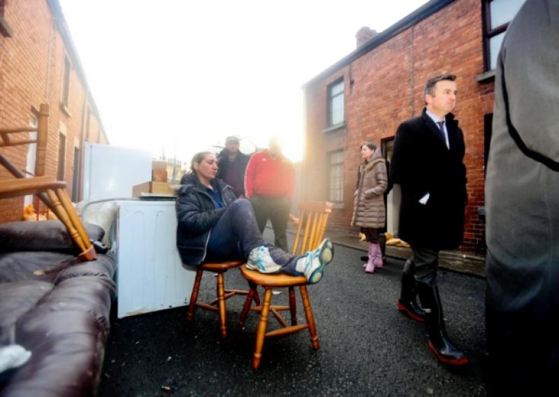 Despair: Geraldine Fitzgerald, Island View Terrace, outside her home while her belongings are dumped in a skip following the floods at the weekend, as Minister Brian Hayes surveys the damage done in St Mary's Park. Picture: Brian Arthur/ Press 22.